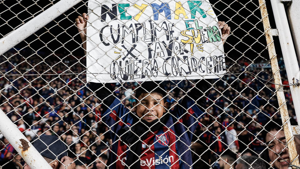 Criança exibe mensagem a Neymar durante a partida entre San Lorenzo e Santos